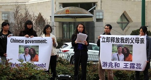 图:美国华盛顿华裔居民游天黛和部分当地法轮功学员,在中共驻美国大使馆前举行新闻发布会,责令中共当局立即释放被绑架她的父母
