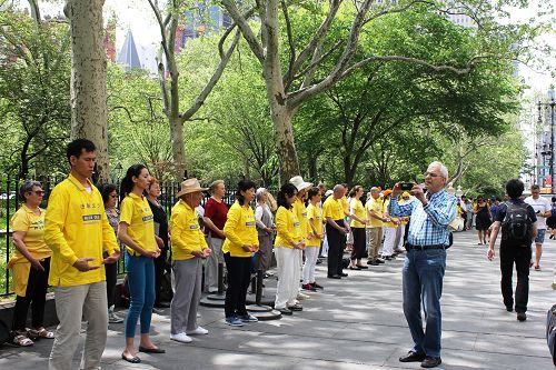 路人被法轮功学员的功法演示所吸引,纷纷拍照