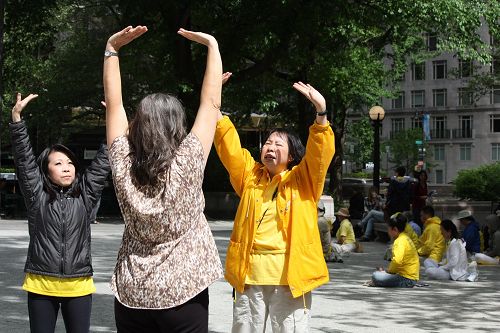 法轮功学员奈里(右)在教巴西人特瑞妮(中)炼法轮功