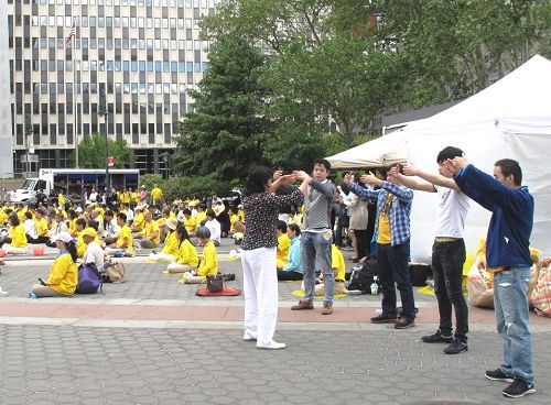 图7-8:二零一五年五月十三日,法轮功学员在纽约曼哈顿的富丽广场集体炼功,有人现场学功