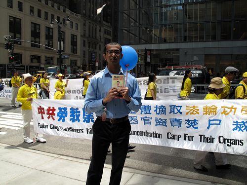 纽约一家会计事务所的审计师吉里什(Girish)正在认真观看法轮功学员的大游行