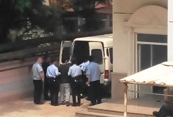 杨峰(中间穿黑衣者)被押上车