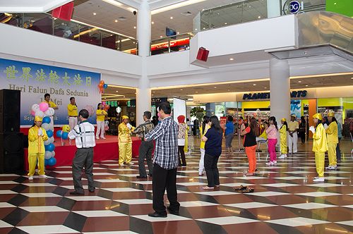 法轮功学员演示功法,一些观众加入到炼功队伍中来
