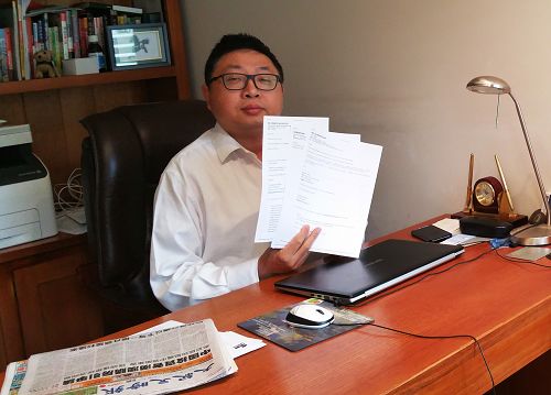 图:帕拉玛塔市(Parramatta City)华裔议员胡煜明展示中共特务冒充法轮功学员的骚扰信。