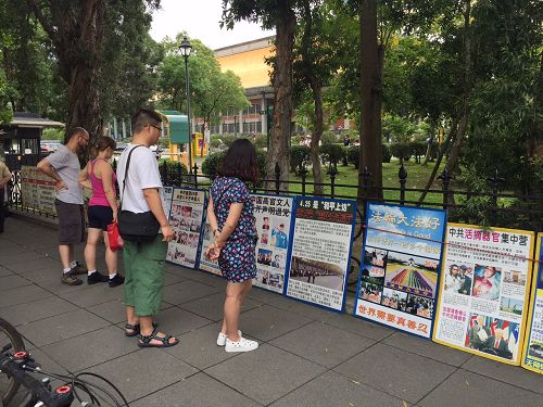 图7-9:法轮功真相吸引民众、尤其是中国大陆观光客的关注,并驻足观看真相。