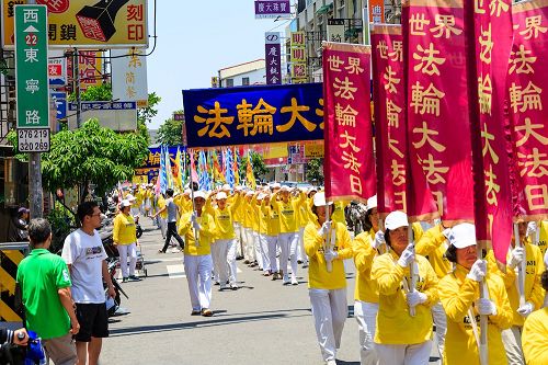 庆祝活动学员们精神抖擞举着旗帜和横幅,上面写着:“庆祝世界法轮大法日”、“法轮大法好”、“真、善、忍”等与民众分享修炼的喜悦。