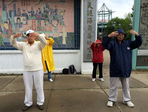 图一:老年大法弟子在细雨中安详的炼功