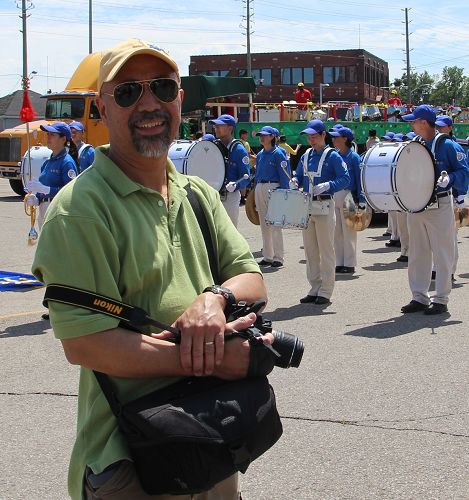 图6:从纽约来加拿大旅游的Arnold是一位摄影爱好者拍了很多天国乐团的照片,他表示会把图片都发到网上。