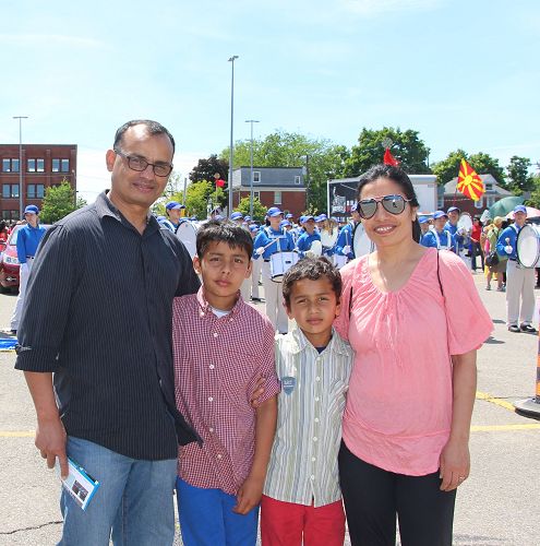 图7:尼泊尔裔的Tulsi 和家人一起在观看天国乐团的出发前练习演奏,他表示,在加拿大能为法轮功发声就是我们的支持!