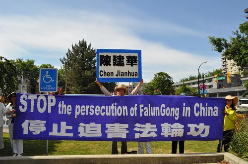 温哥华法轮功学员在市政厅前沿街拉起横幅,责令中共停止迫害