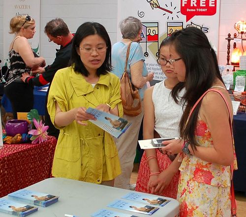 图3:素食节同时在室内和室外进行。图为法轮功学员在室内设立了真相展位,民众正在了解真相。