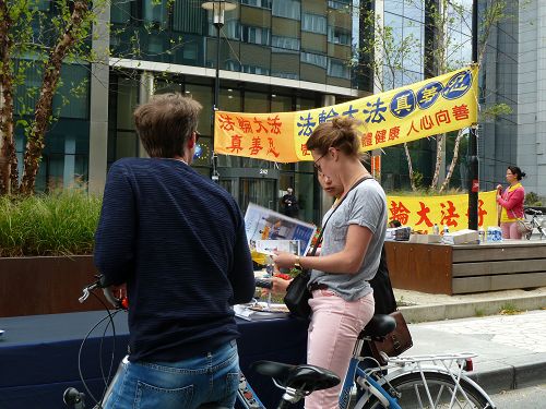 图3-9:许多人经过活动现场驻足了解真相。