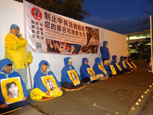 图4:七月二十日,奥克兰的部份法轮功学员聚集在中领馆外举办烛光夜悼。