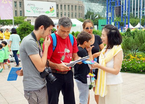 图16:以色列游客lebovits一家从学员那了解到法轮功真相后,都在联署书上签了名。