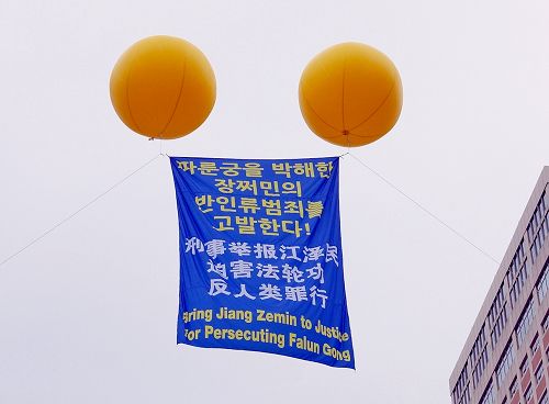 图10:活动现场首尔广场上空飘扬着“刑事举报江泽民迫害法轮功反人类罪行”的大型气球。