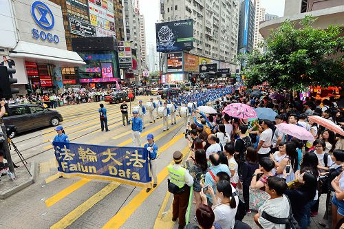 图3-4:香港法轮功学员于二零一五年七月十九日,游行从港岛区英皇道、轩尼诗道,途经闹市铜锣湾、湾仔、中环,最终到西环中联办,历时约四小时,沿途吸引港民及中西旅客观看。