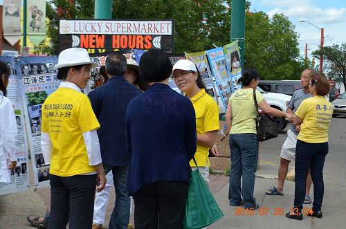 图2:埃德蒙顿法轮功学员在集会现场向华人讲真相