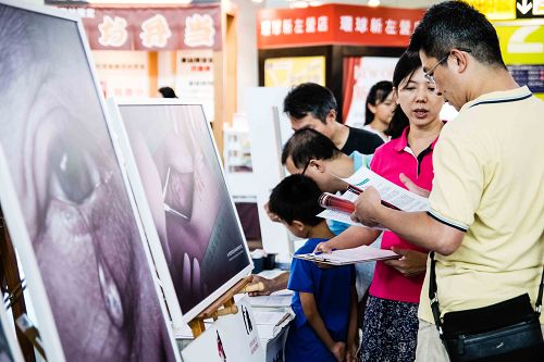 图1-2:在高雄市台铁新左营火车站中央玄关征签,民众了解真相后纷纷签名连署,谴责中共暴行。
