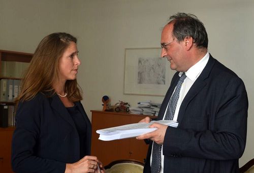 图2:DAFOH代表Katja Hausmann (左)向人权专员Gerhard Doujak博士(右)递交一年来收集到的两百多万签名支持“制止强摘法轮功学员器官”的征签副本。