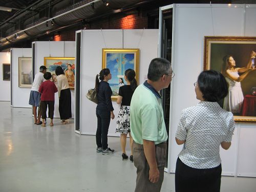 图2民众仔细赏画,并聆听导览员解说。