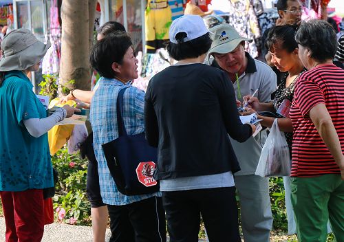 高雄市法轮功学员设展位向民众征签,制止中共迫害法轮功,民众响应热烈。了解真相的人们纷纷签名,期盼早日将恶人绳之以法。