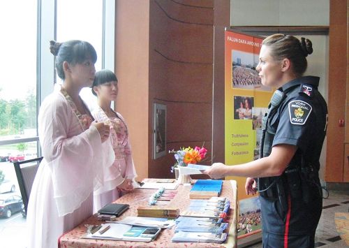 图3:女警官到法轮功展位了解真相。
