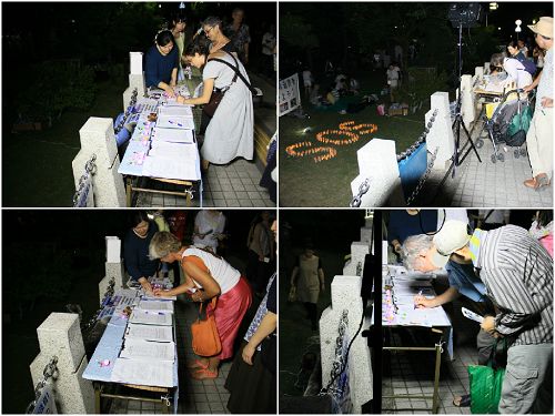 烛光守夜活动中,人们在继续签名支持法轮功