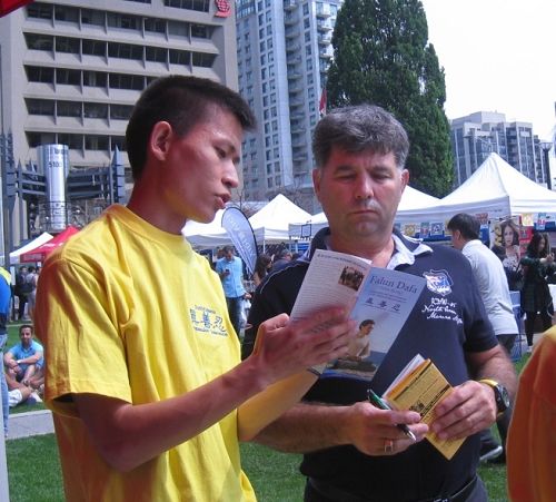 图12:木雕家George Georgeio先生正在聆听法轮功学员给他讲述真相。