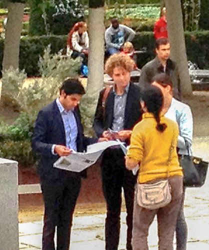 图1-3:比利时法轮功学员在欧洲器官移植大会举行之际,在欧洲议会总部大楼前,向与会的各国医生与在此过往的各界人士,传播法轮功的真相,揭露中共活摘法轮功学员器官的罪恶。