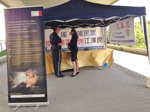 图8:二零一五年九月十八日,在维也纳联合国大厦外,负责当天法轮功活动安全的警察耐心听法轮功学员讲真相