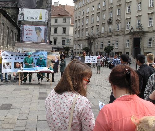 图:观众通过真相资料了解到法轮功学员的诉江大潮