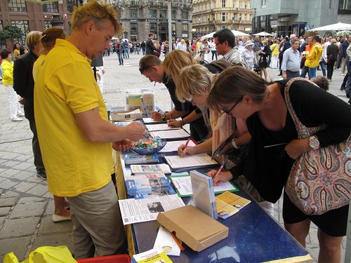 图:在上演讲真相街头剧的两个小时里,签名谴责中共迫害和活摘器官罪恶的人明显增多