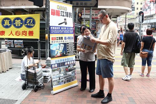 图:法轮功学员小红满脸笑容讲真相,赢得不少人签名举报江泽民。