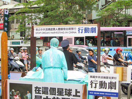 图:模拟中共活摘法轮功学员器官的行动剧引起路过的摩托车骑士和公车上的乘客聚焦和震惊。
