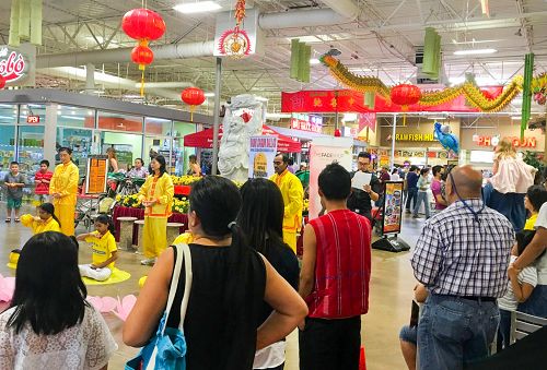 图:法轮功学员亚洲时代广场的大厅演示五套功法,吸引各族裔人士驻足