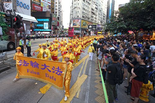 图8-11:一千多名法轮功学员的游行队伍吸引游客驻足聚焦并拍照。