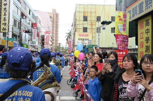 '图3~4:街道两侧聚集众多民众,纷纷拍照,拍手叫好。'