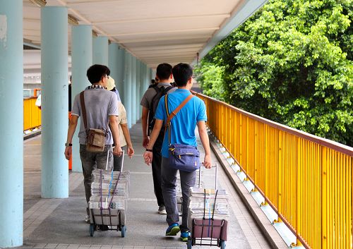 图2:台湾青年学子们一大早就拉着各种法轮功真相材料推车搭火车到景点街头派发并且讲真相。