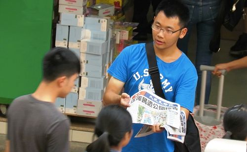 图3 - 5:人们接过报纸了解法轮功真相。