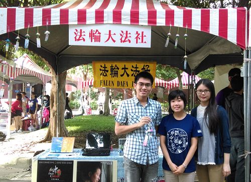 图2. 卓廷威(左一,穿格子上衣青年)于二零一五年九月十日在师大“法轮大法社”迎新摊位上,与青年学子合影。