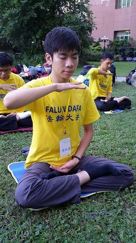 图2. 余以澄(前一)参加二零一四年七月举办的青年学子交流营,图为当时在中国医药大学校园炼功的照片。
