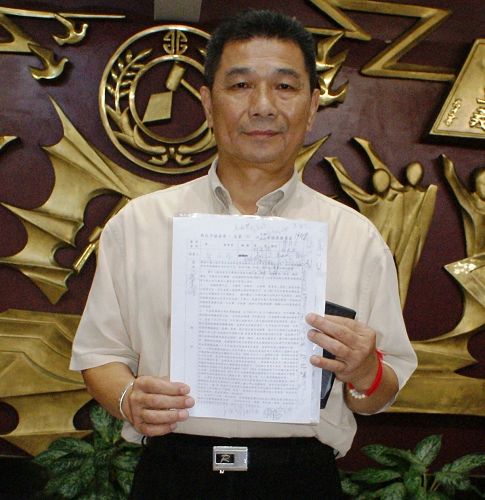 '图2:提案人新北市议员郑金隆手持提案联署书。'