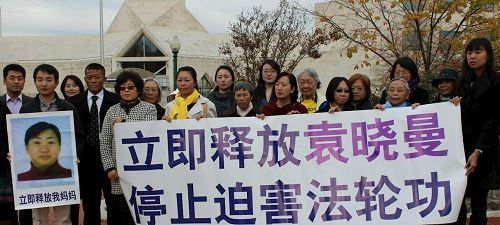 '图:二零一六年十一月十四日中午,居住在美国华府地区的青年法轮功学员杜海芃与当地部份法轮功学员,在中共驻华府大使馆前举行集会,要求中共当局立即无条件释放在大陆遭绑架和关押的母亲袁晓曼。'