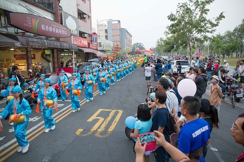 '图5:活泼喜气的腰鼓队吸引很多民众用手机拍照留念。'
