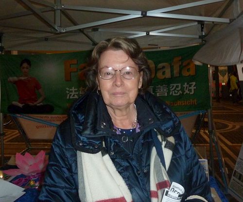 '图8:法兰克福的塞尔女士签名反对活摘器官,还想建议她来自中国的孙媳妇来法轮功信息展位看看。'