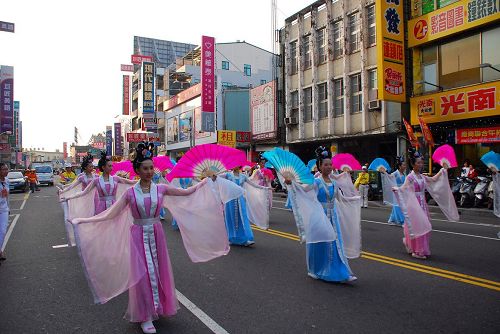 '图3:法轮功学员组成的仙女队跟着乐团,沿路赠送纸莲花,带来喜庆气息'
