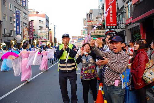 '图7~8:雄壮音乐震撼整条街道,吸引了民众的眼光,人们纷纷鼓掌'