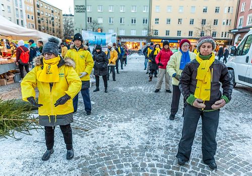 '图1~2:瑞典法轮功学员在林雪平(Linköping)市中心广场举行讲真相反迫害征签活动,学员们向民众演示法轮功的五套功法。'
