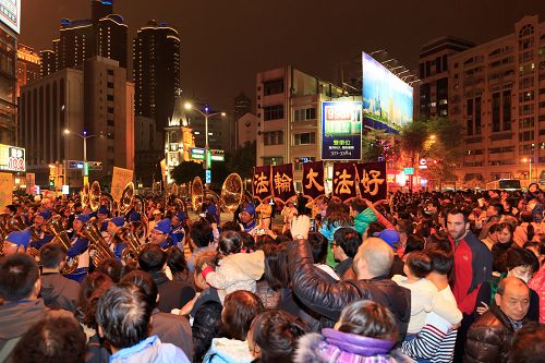 高雄庆元宵游行活动,两侧的观众被天国乐团盛大的阵容震撼,有群众看到法轮功天国乐团队伍来了,就高举双手鼓掌,也有群众高喊“法轮大法好”。