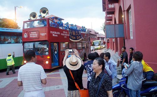 中国游客惊喜民众开心看到天国乐团在荷兰红屋广场演奏,抓紧时间拍照、摄影留念。